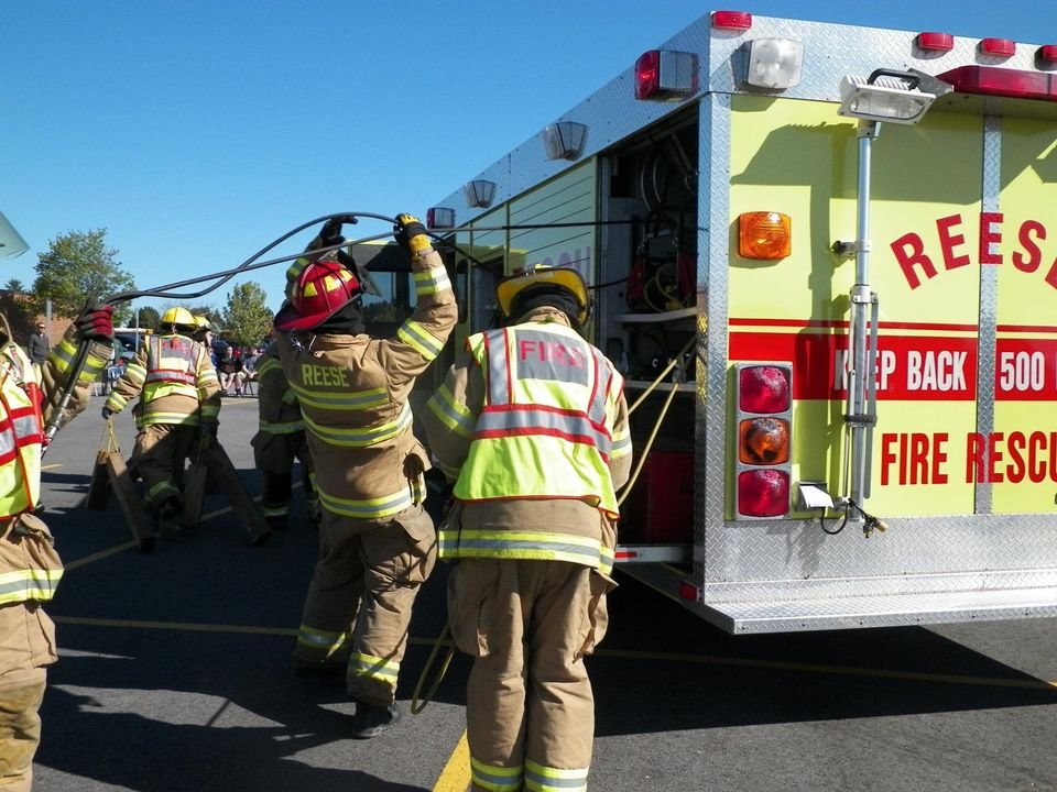 Reese Fire Rescue members in turnout gear working beside apparatus